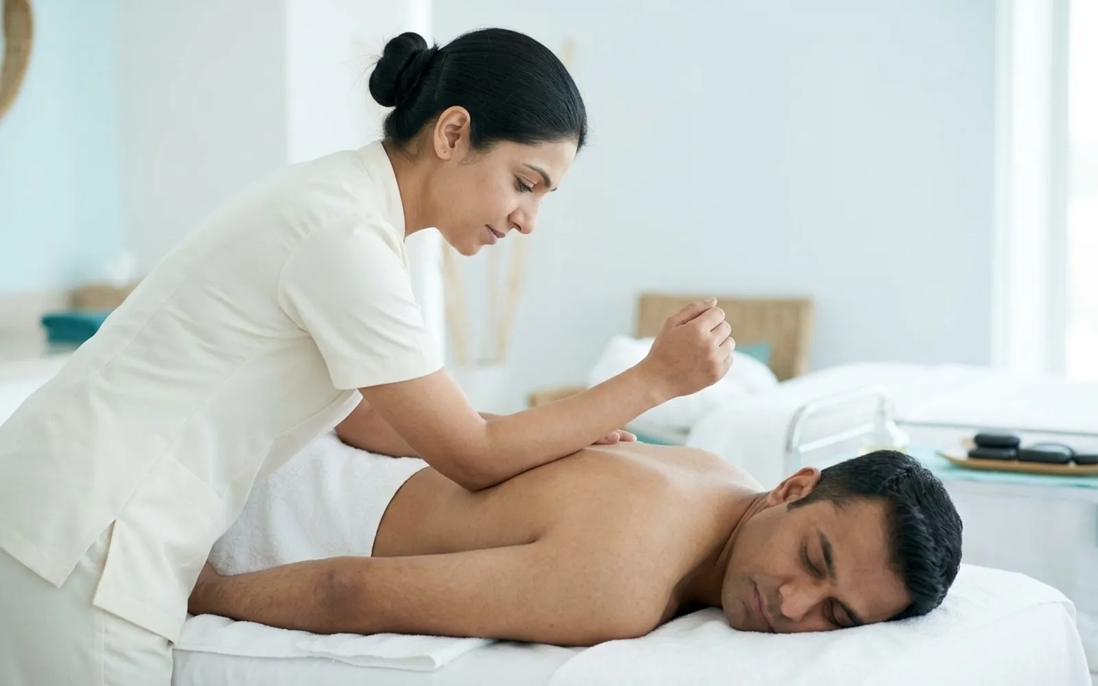Therapist using her forearm with slow, firm pressure on the back of a client