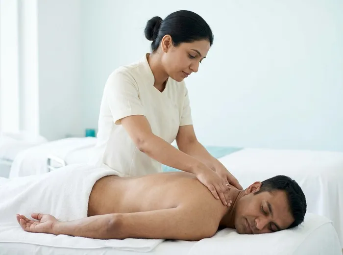 Therapist massaging the back and neck of a client